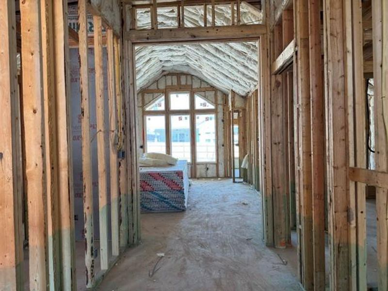 Unveiling the future, this image captures the potential of a residence mid-construction, featuring wood framing and a vaulted ceiling.