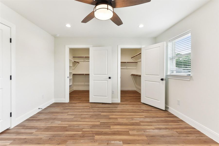 Unfurnished bedroom with a walk in closet, baseboards, light wood-style floors, and recessed lighting Unfurnished bedroom with a walk in closet, baseboards, light wood-style floors, and recessed lighting
