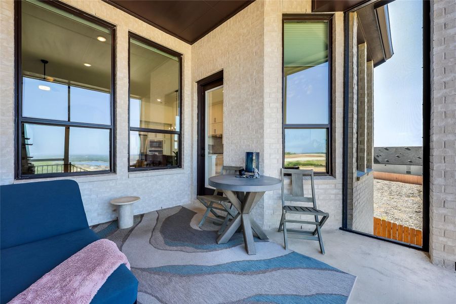 An inviting covered patio features smooth concrete flooring under a dark wood ceiling. An inviting covered patio features smooth concrete flooring under a dark wood ceiling.