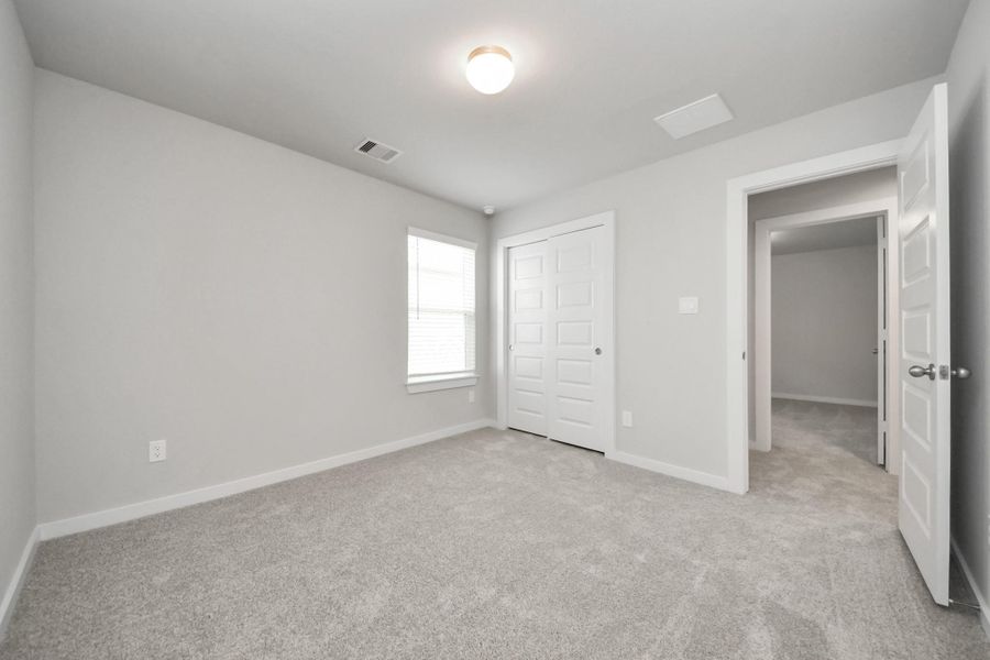 Generously sized secondary bedrooms featuring spacious closets, soft and inviting carpeting underfoot, large windows allowing plenty of natural light, and the added touch of privacy blinds for your personal retreat. Sample photo of completed home with similar floor plan. Actual colors and selections may vary.