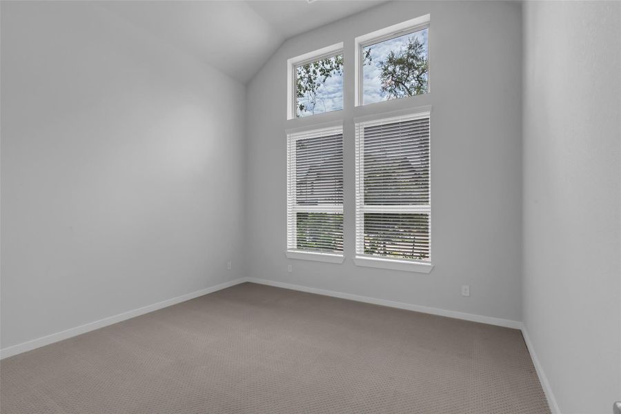 Primary bedroom features a wall of windows for abundant natural light.
