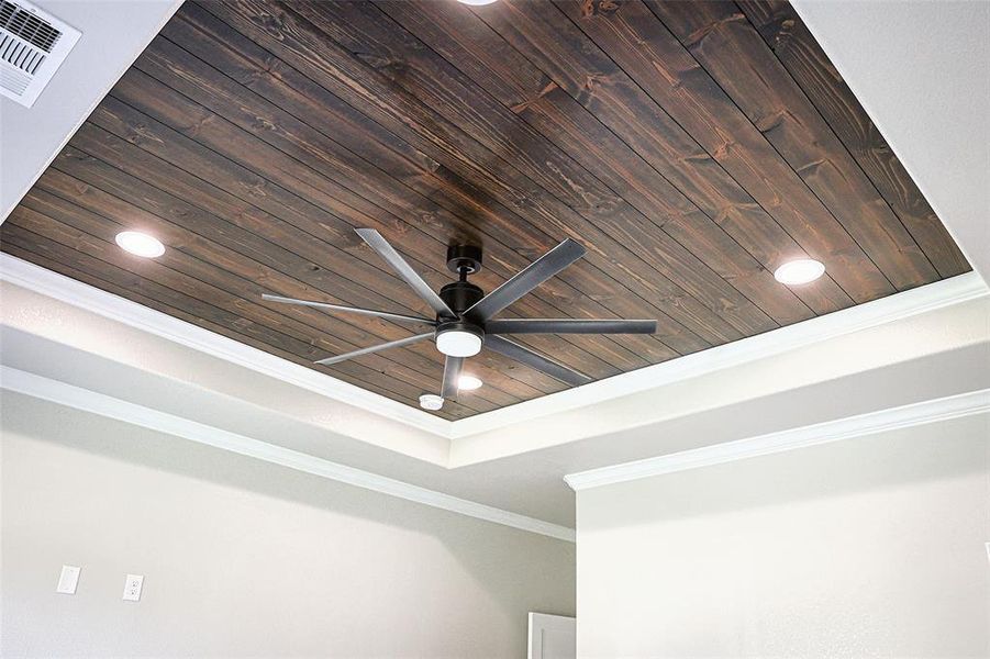 Primary bedroom has crown moldings and decorative tray ceiling.