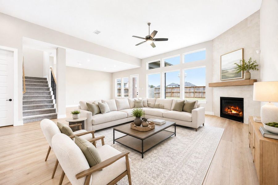 The spacious living area features soaring ceilings, a wall of windows for abundant natural light, and a cozy gas log fireplace as the room's focal point. Virtually staged. The spacious living area features soaring ceilings, a wall of windows for abundant natural light, and a cozy gas log fireplace as the room's focal point. Virtually staged.