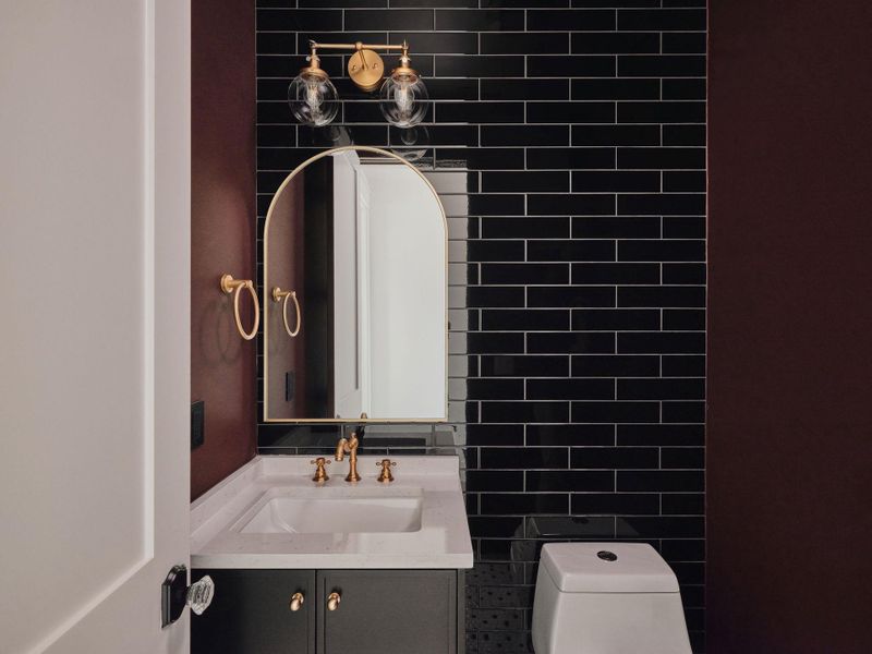 Half bathroom featuring vanity and tile walls