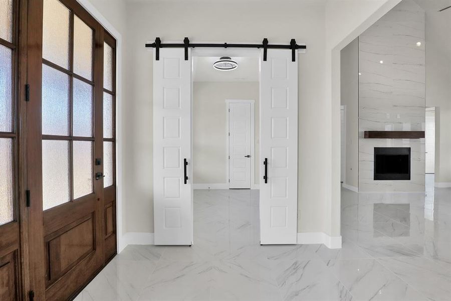 Foyer with a barn door, a healthy amount of sunlight, and a fireplace