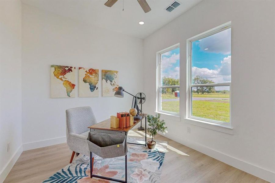 Home office featuring ceiling fan and light hardwood / wood-style floors