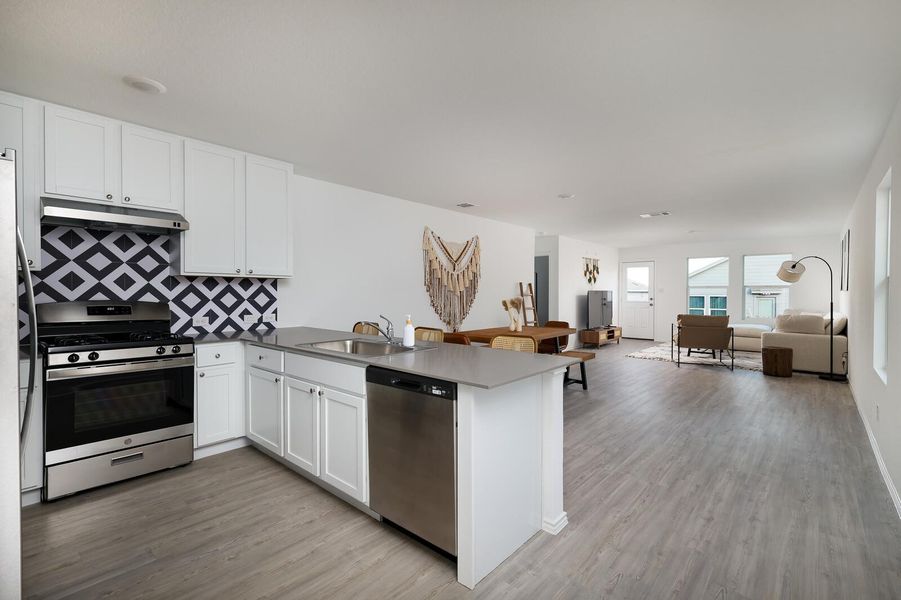 Kitchen featuring open floor plan, a peninsula, stainless steel appliances, and white cabinets Kitchen featuring open floor plan, a peninsula, stainless steel appliances, and white cabinets
