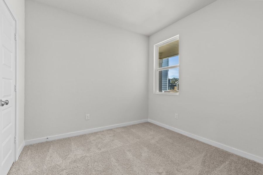 A room with a carpet and a window.