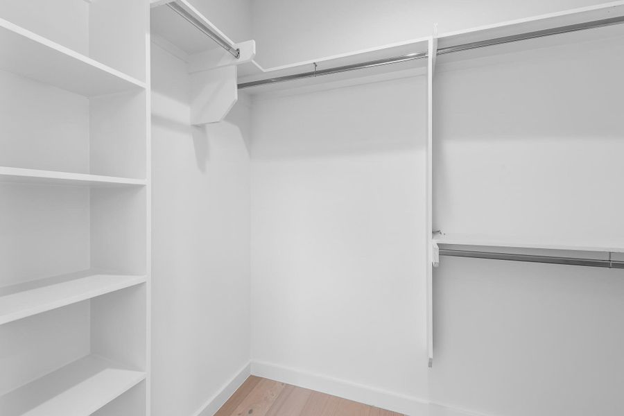 Ample shelving and hanging space define this highly organized walk-in closet.