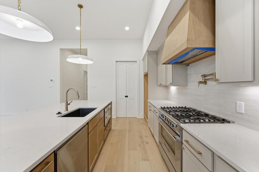 The kitchen boasts quartz countertops and stainless steel appliances,