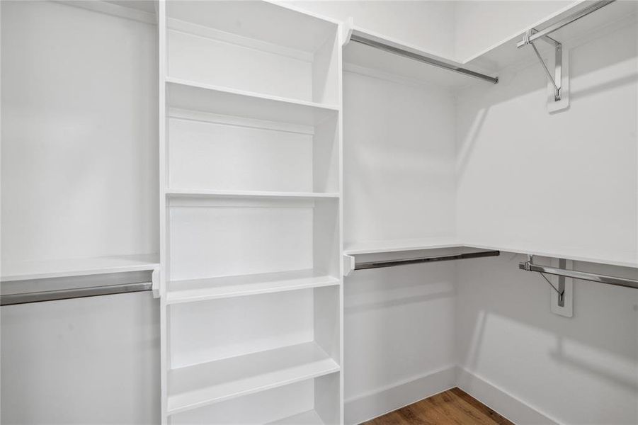 Spacious walk-in closet with built-in shelving and ample hanging space, offering a functional and organized solution for all your storage needs.