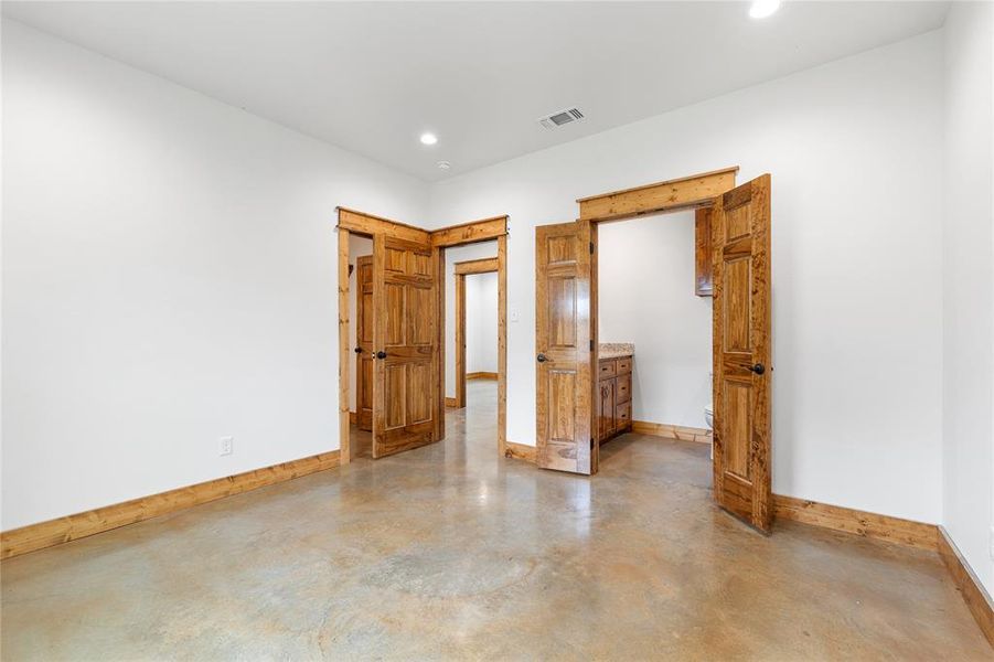 Master bedroom featuring concrete flooring, baseboards, and recessed lighting Master bedroom featuring concrete flooring, baseboards, and recessed lighting