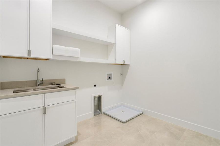 Laundry area featuring baseboards, a sink, cabinet space, electric dryer hookup, and hookup for a washing machine