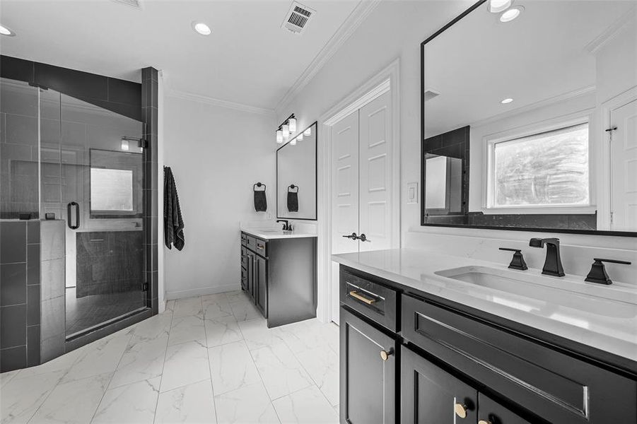 Full bathroom featuring ornamental molding, a shower stall, recessed lighting, two vanities, and light marble finish flooring Full bathroom featuring ornamental molding, a shower stall, recessed lighting, two vanities, and light marble finish flooring