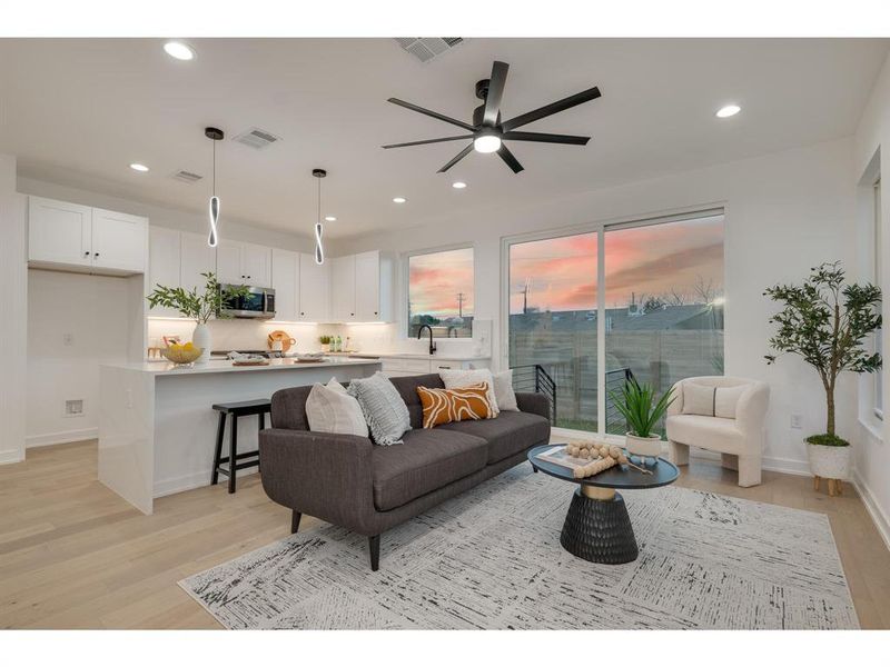 Bright and open living space, illuminated by elegant recessed lighting and chic black fixtures, creating an inviting atmosphere of contemporary style and comfort.