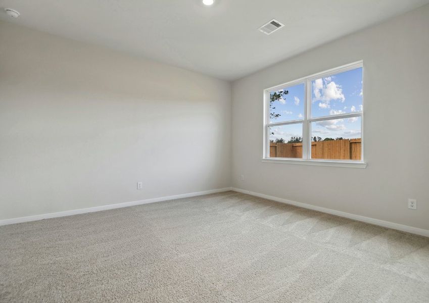 Master bedroom with a window overlooking the back yard