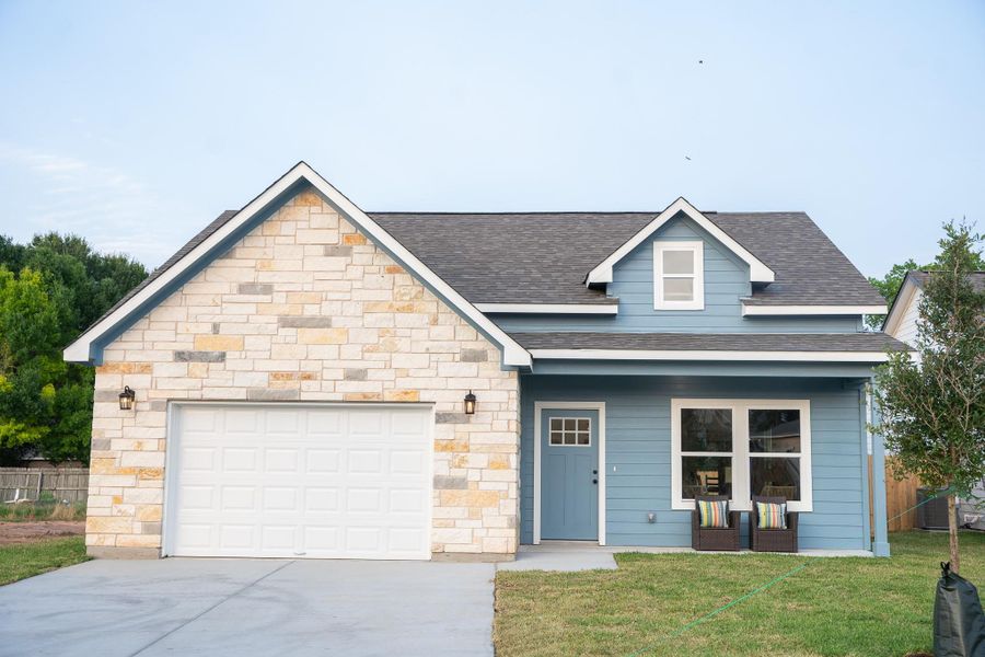 View of front facade featuring concrete driveway, roof with shingles, a garage, and stone siding View of front facade featuring concrete driveway, roof with shingles, a garage, and stone siding