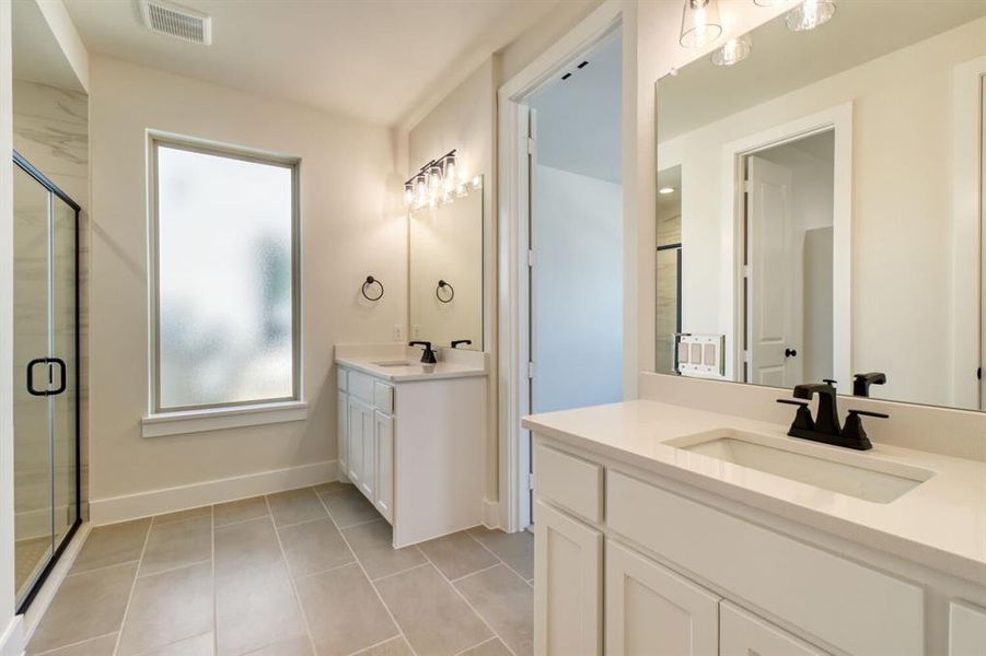 Bathroom with a shower stall, two vanities, and light tile patterned floors Bathroom with a shower stall, two vanities, and light tile patterned floors