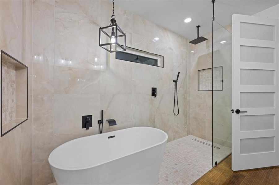 Full bathroom featuring a soaking tub, a marble finish shower, tile walls, and recessed lighting Full bathroom featuring a soaking tub, a marble finish shower, tile walls, and recessed lighting