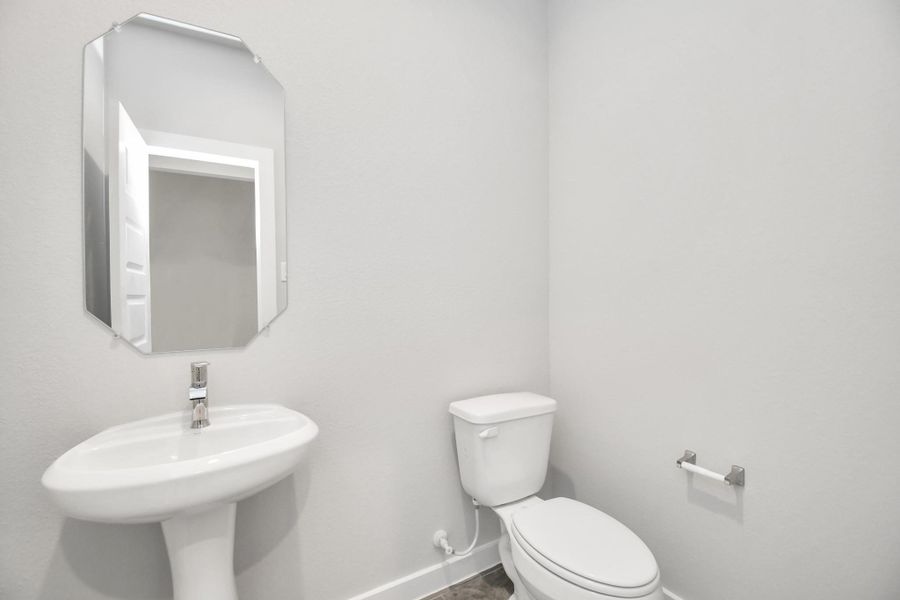 This half bathroom features a stylish pedestal sink, modern hardware, and bright recessed lighting, creating a sleek and inviting space. This half bathroom features a stylish pedestal sink, modern hardware, and bright recessed lighting, creating a sleek and inviting space.