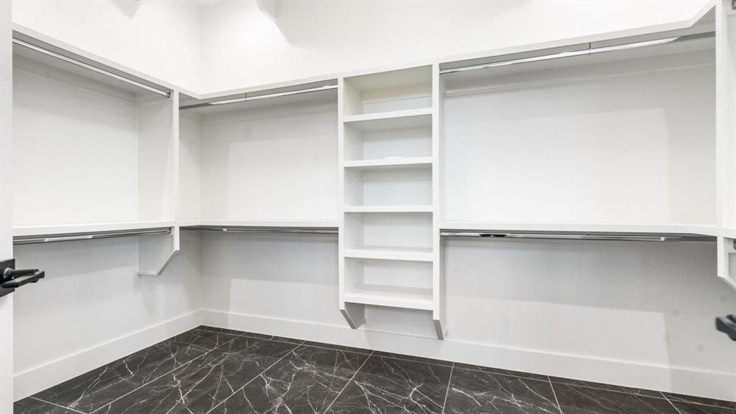 Spacious closet with dark tile floors