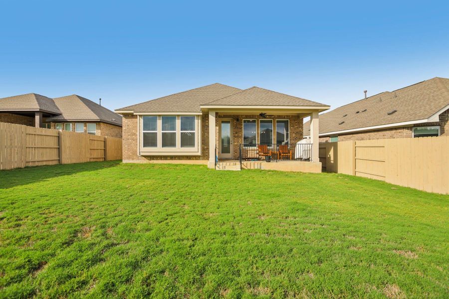 Back of house with brick siding, a patio, a fenced backyard, and a ceiling fan Back of house with brick siding, a patio, a fenced backyard, and a ceiling fan