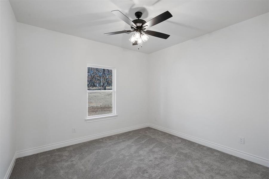 Carpeted spare room with ceiling fan