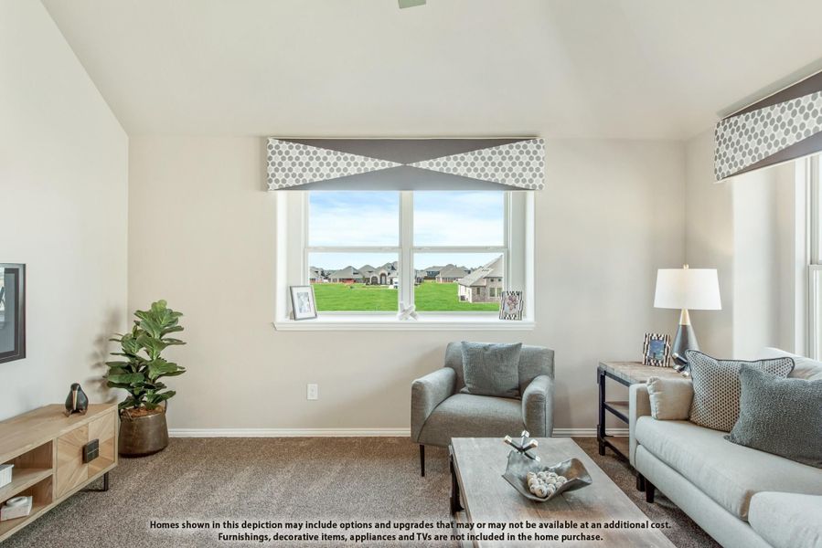 Living room with vaulted ceiling, gray sofa, carpet flooring, and large window overlooking a green yard