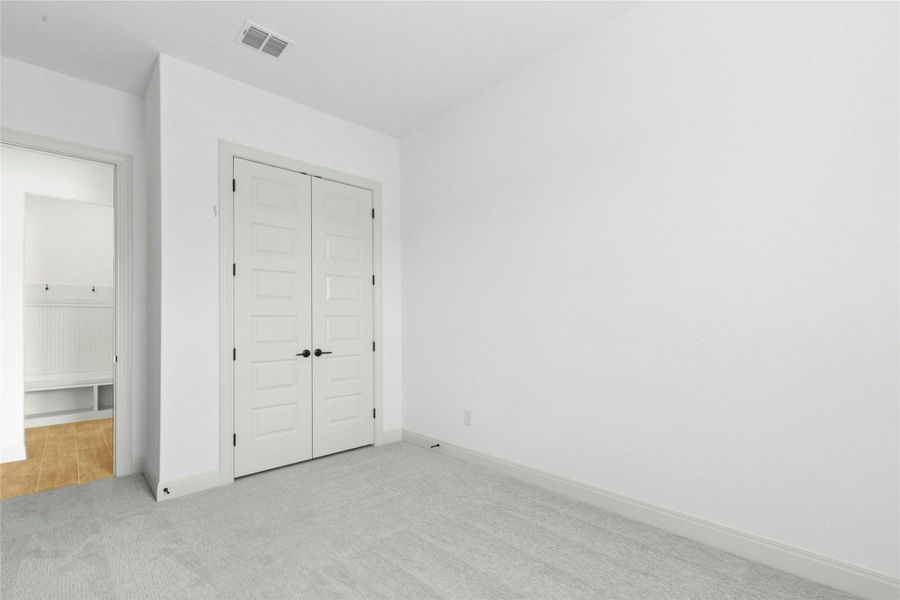 Unfurnished bedroom featuring carpet floors and a closet Unfurnished bedroom featuring carpet floors and a closet