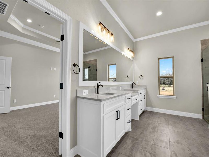 Bathroom featuring vanity, a shower with door, and ornamental molding