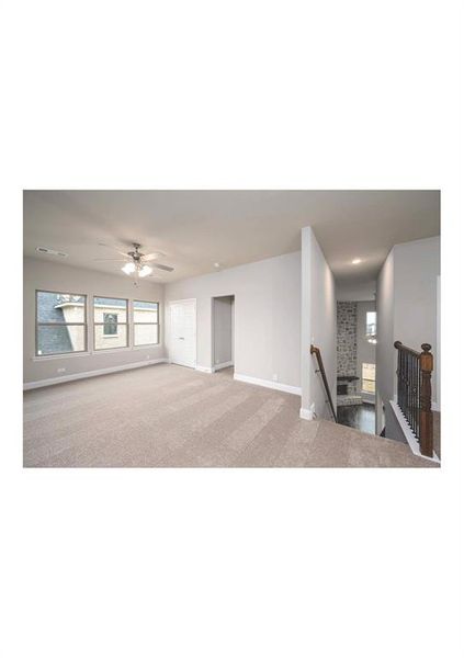 Unfurnished living room with light carpet and ceiling fan