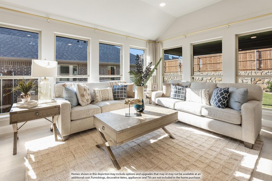 Bright living room with vaulted ceiling, two neutral sofas, wood coffee table, and large windows overlooking backyard Bright living room with vaulted ceiling, two neutral sofas, wood coffee table, and large windows overlooking backyard