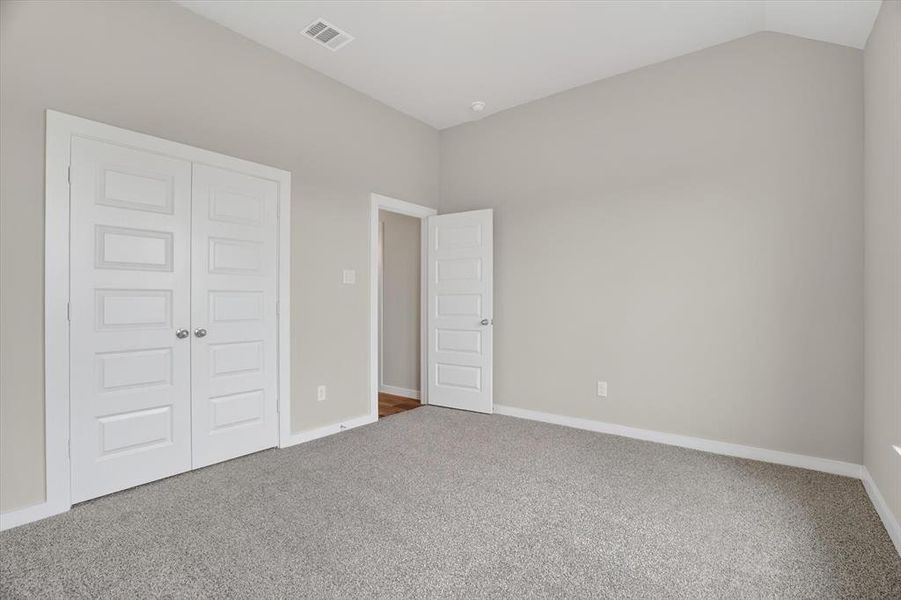 Interior room featuring light gray wall paint and gray carpet flooring Interior room featuring light gray wall paint and gray carpet flooring