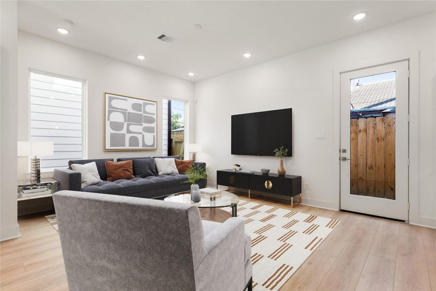 This bright and airy Living Room offers a spacious layout ideal for both relaxing evenings and lively gatherings. Designed for comfort and connection, it features vinyl plank flooring, large windows, high ceilings with recessed lighting, access door to the outside space and access to the stunning kitchen—perfect for everyday living and entertaining alike. *Virtually Staged