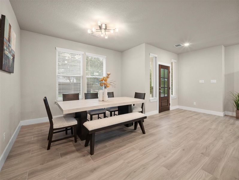 Dining room with light wood-style flooring, a textured ceiling, and recessed lighting Dining room with light wood-style flooring, a textured ceiling, and recessed lighting