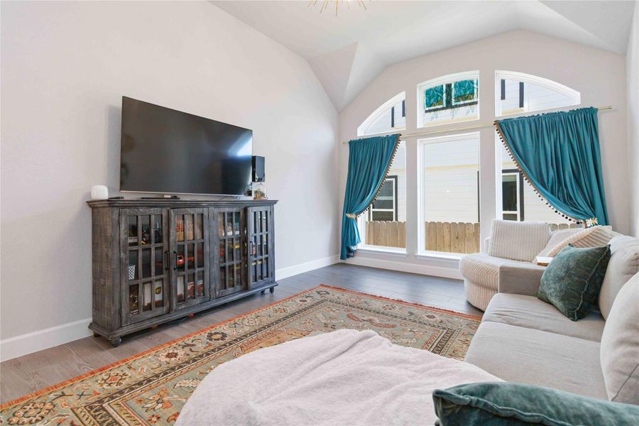 Living area featuring wood finished floors and vaulted ceiling Living area featuring wood finished floors and vaulted ceiling