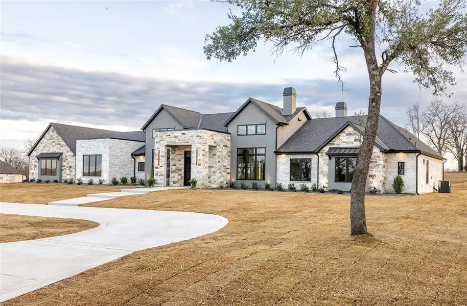 Contemporary stone and stucco exterior with dark trim windows