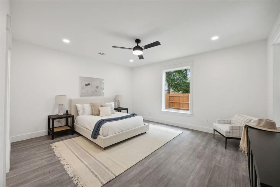 First floor primary bedroom with recessed lighting and a ceiling fan