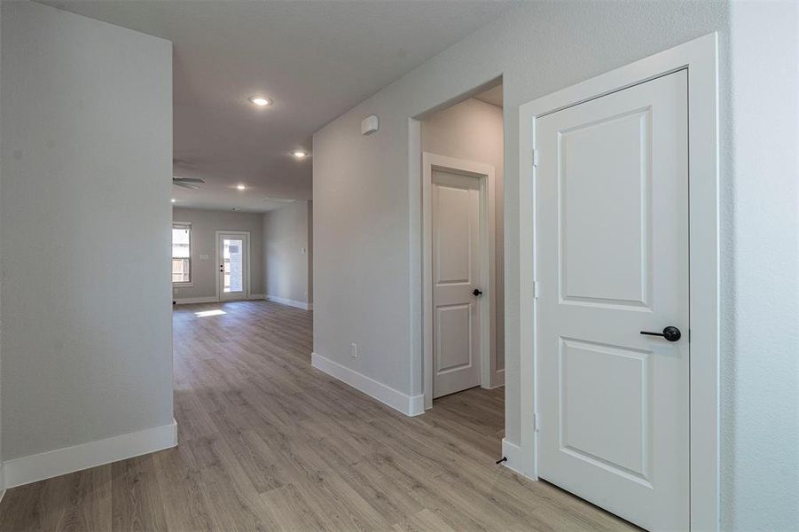 Hallway featuring light wood finished floors and recessed lighting