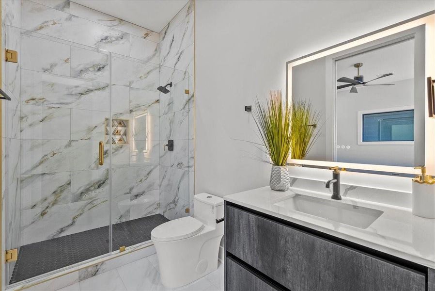 The first floor bedroom bathroom offers an immaculate, oversized walk-in shower with high-end, detailed finishes that feel truly luxurious.