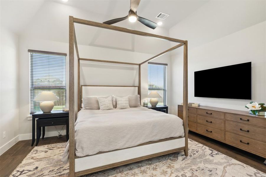 Bedroom featuring multiple windows, dark hardwood / wood-style floors, vaulted ceiling, and ceiling fan