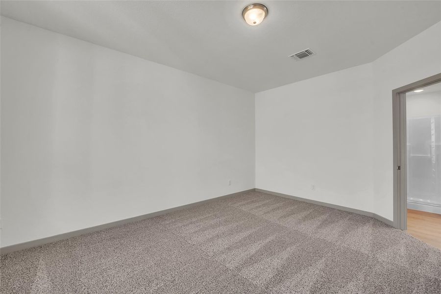Spare room with light colored carpet and baseboards