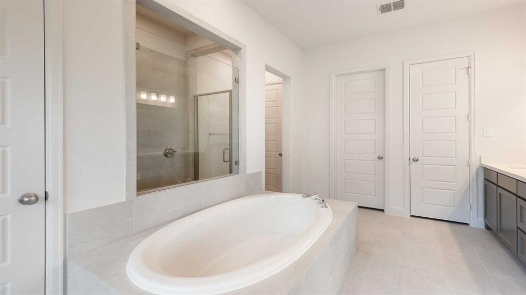 Bathroom with tile patterned floors, vanity, and separate shower and tub