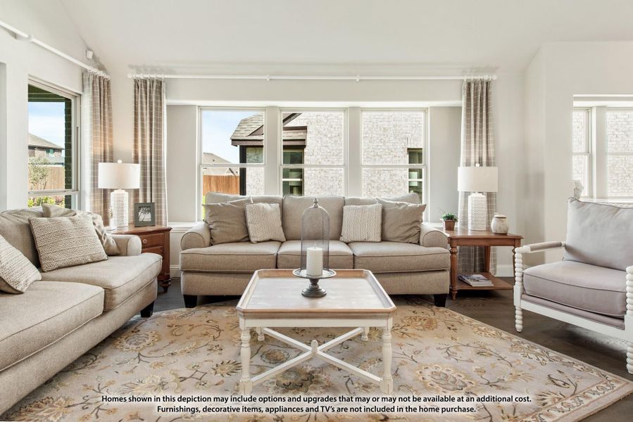 Living room with beige sofas, white coffee table, floral area rug, and large windows with natural light Living room with beige sofas, white coffee table, floral area rug, and large windows with natural light