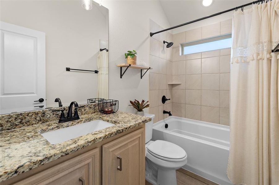 Bathroom featuring shower / bathtub combination with curtain and vanity Bathroom featuring shower / bathtub combination with curtain and vanity