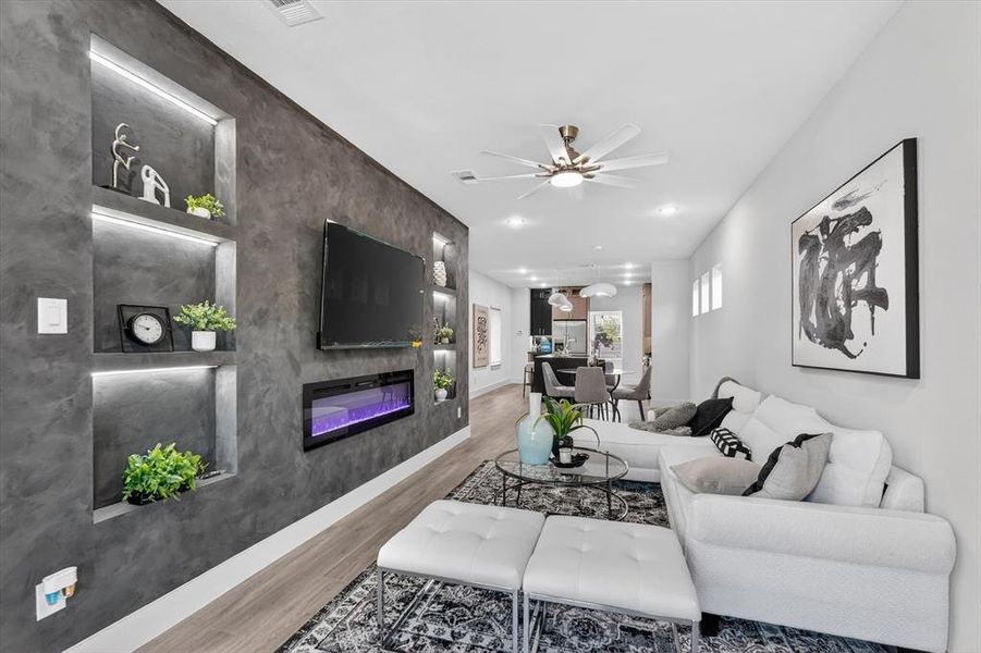 Contemporary living area featuring a built-in media wall with integrated shelving and accent lighting
