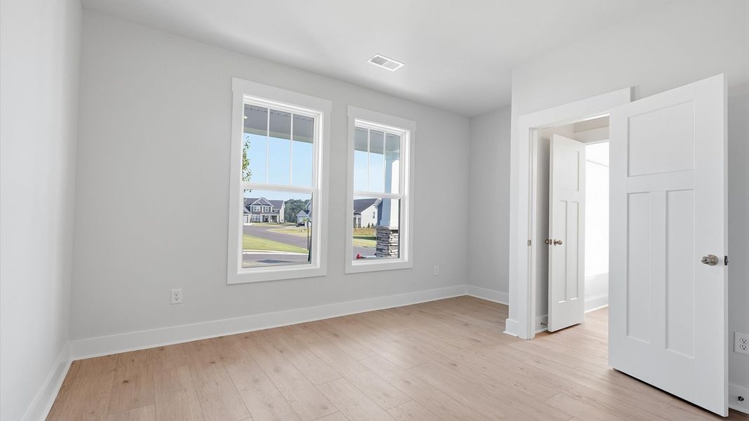 Functional secondary bedrooms with hardwood flooring and modern touches in an exceptional layout