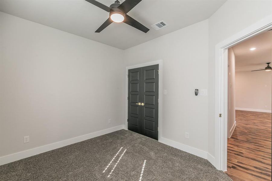 Empty room featuring ceiling fan and dark hardwood / wood-style floors