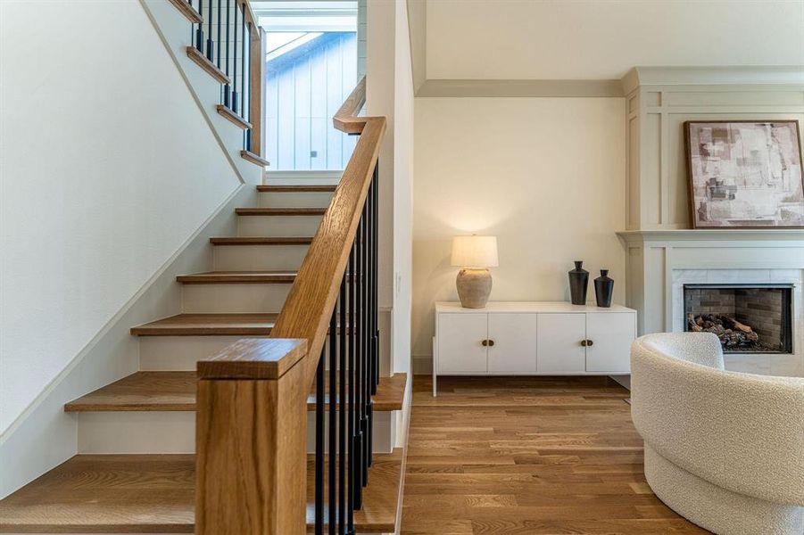Stairway featuring wood finished floors and a fireplace