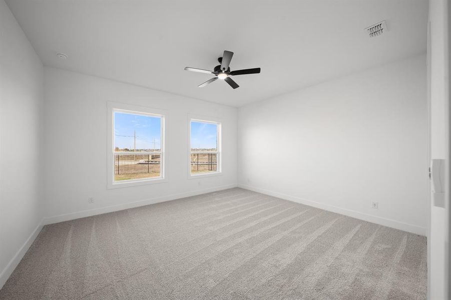 Empty room featuring light carpet and a ceiling fan